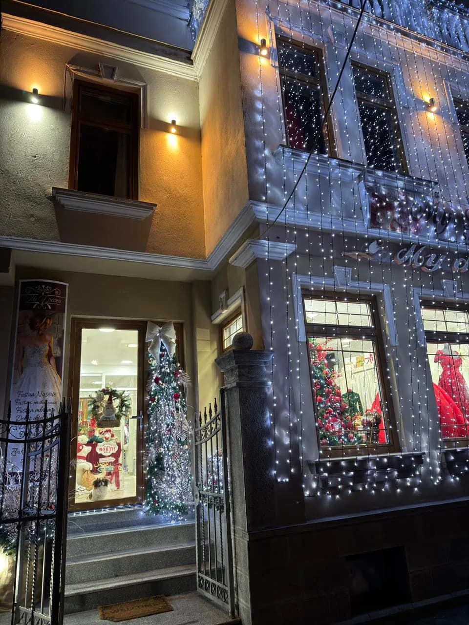 Hyrja e sallonit My Dream në Korçë me drita festive dhe fustane në vitrinë Hyrja e sallonit My Dream në Korçë me drita festive dhe fustane në vitrinë